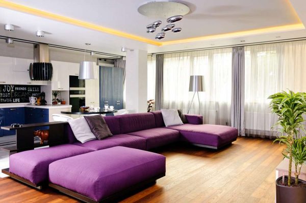 Большой фиолетовый диван в совмещенной гостиной-кухне