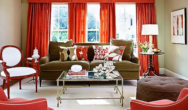 Эффектное сочетание красных штор и темно-зеленого дивана